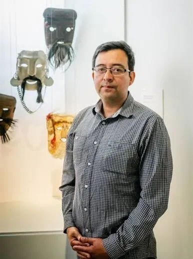 Antonio Chiwaikura frente a una selección de máscaras.